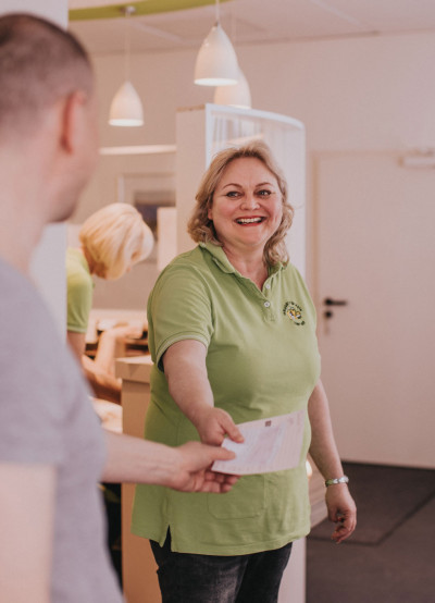 Bild 08 - Mitarbeiterin ueberreicht Rezept.jpg